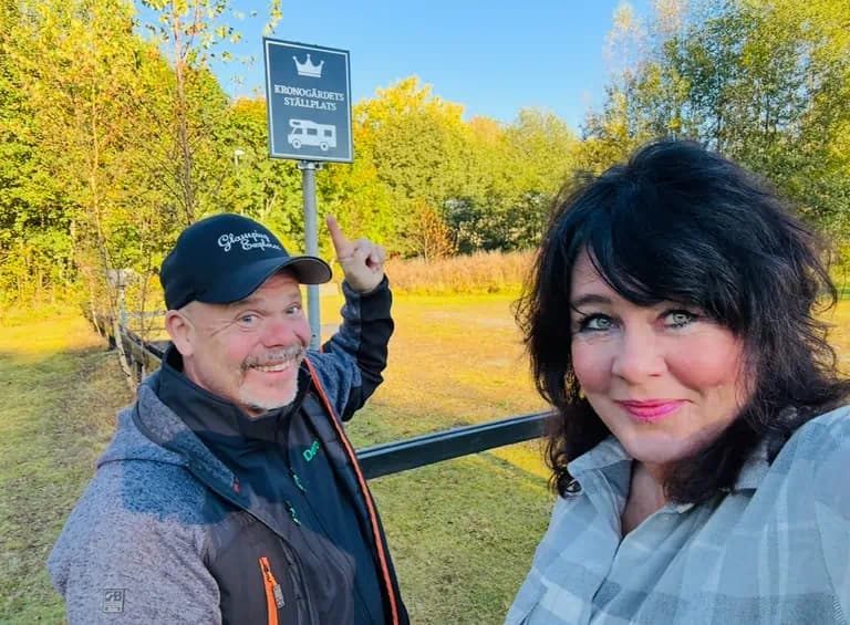 Jeanette och Robert vid Kronogärdets Ställplats-skylt